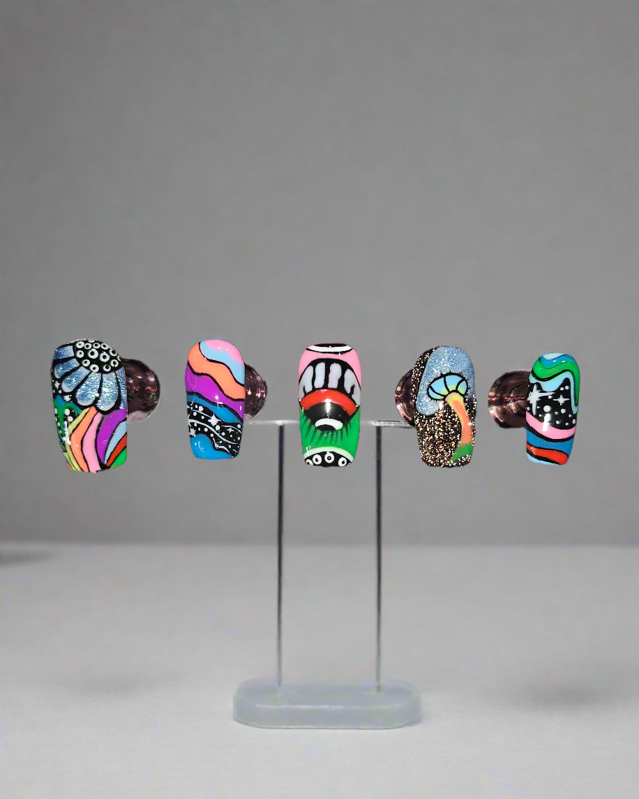 Set of five colorful nail art designs on a dark surface